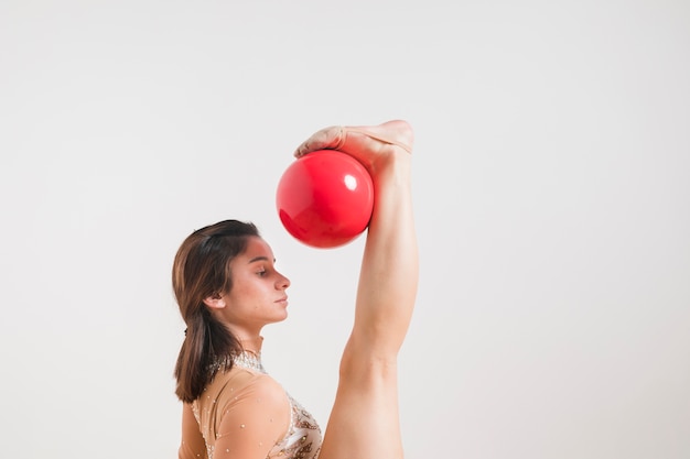 Rythmic gymnast posing with the ball