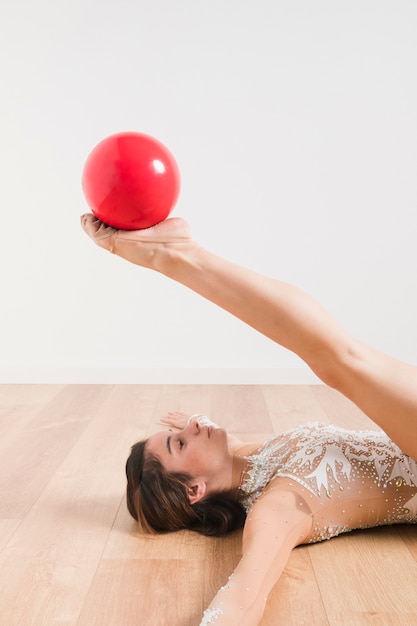 Rythmic gymnast posing with the ball