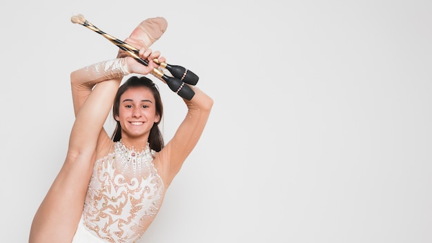 Free photo rythmic gymnast posing with the juggling clubs