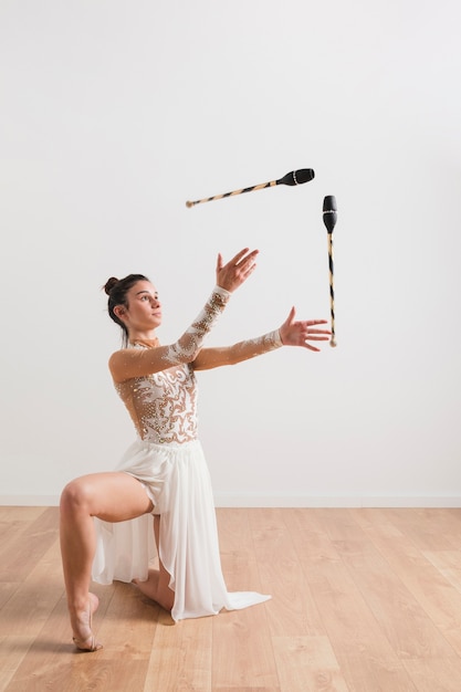 Ритмичная гимнастка позирует с жонглирующими клубами