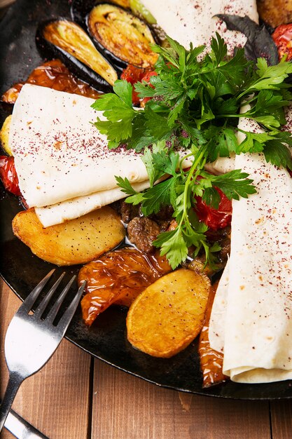 Sac ici, traditional caucasian meal with fried meat and vegetables served with lavash