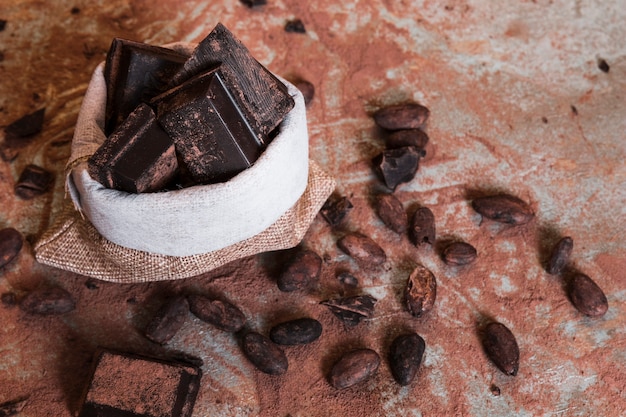 Sack of dark chocolate pieces with cocoa beans