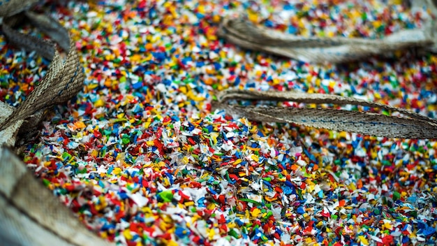 Free photo sack of sorted multicoloured shredded plastic garbage at waste recycling factory