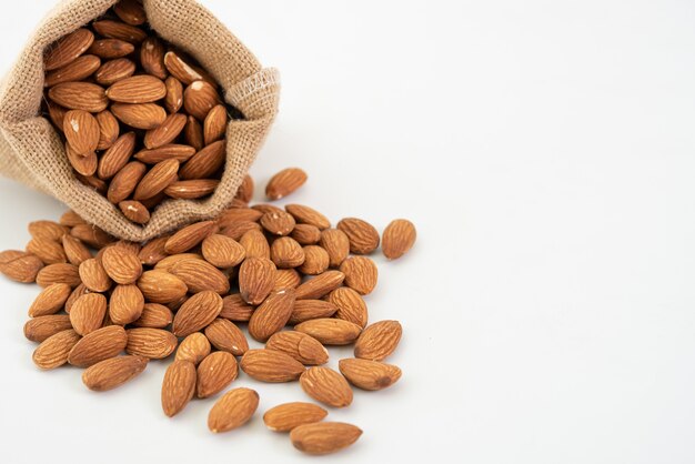 Sack with almond on white background.