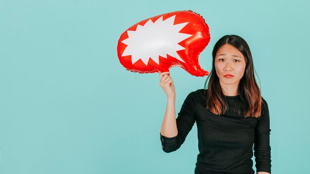 Грустная азиатская женщина с речевым воздушным шаром