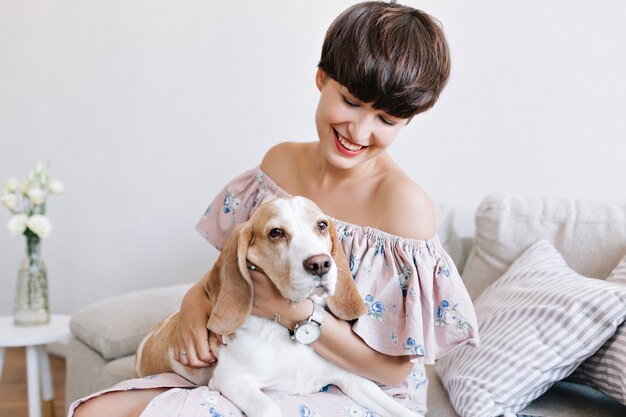 Sad beagle dog looking away while beautiful girl with charming smile posing