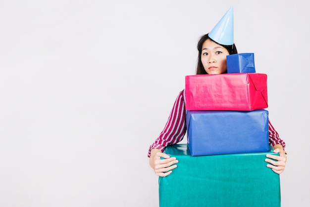 Sad birthday girl with present boxes