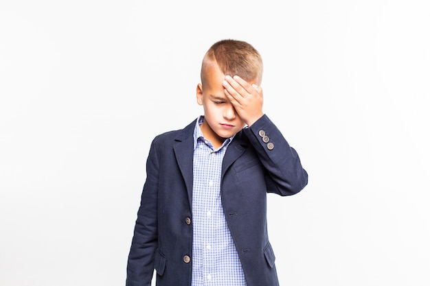 Sad boy holding head isolated on white wall