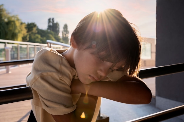 Foto gratuita vista laterale del ragazzo triste all'aperto