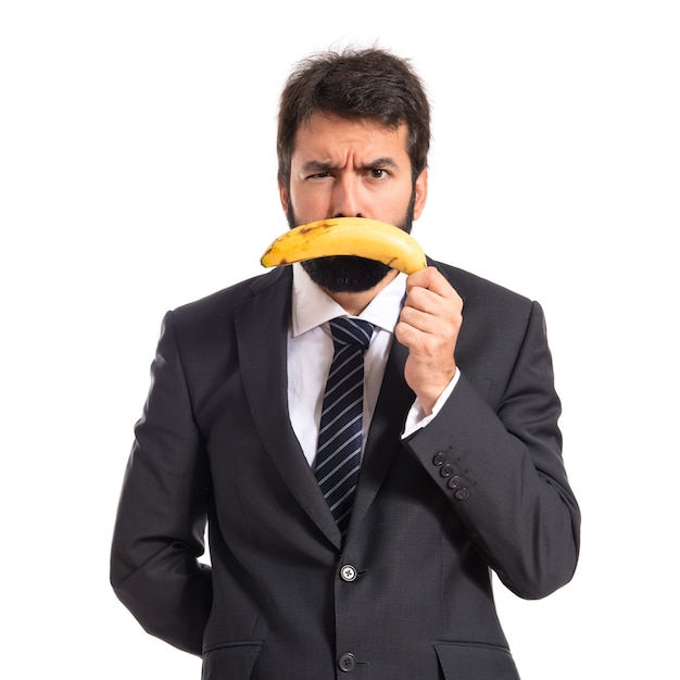 Sad businessman with banana over white background