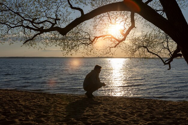 Sad and contemplative person near lake