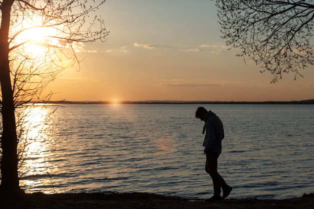 Persona triste e contemplativa vicino al lago