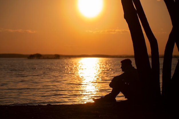 Foto gratuita persona triste e contemplativa vicino al lago