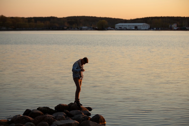 Free photo sad and contemplative person near lake