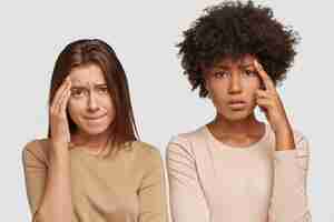 無料写真 悲しい落胆したストレスの多い若い女性は、頭痛があり、額に手を置き、表情が不快で、カジュアルな服装をしています