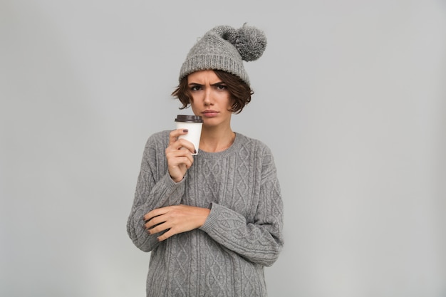 Giovane donna dispiaciuta triste che beve caffè.