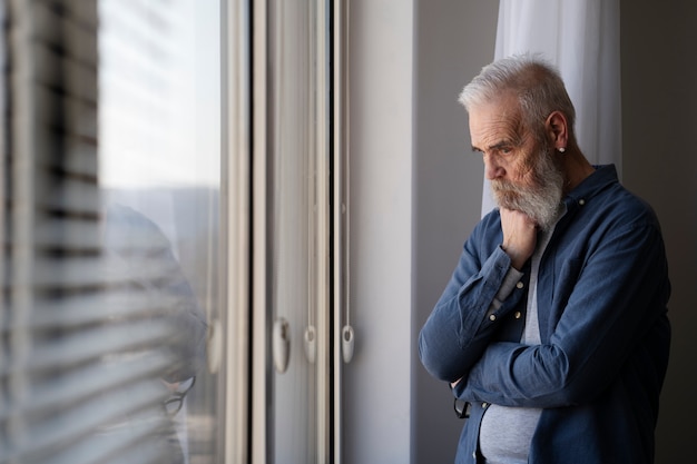 Foto gratuita uomo anziano triste a casa