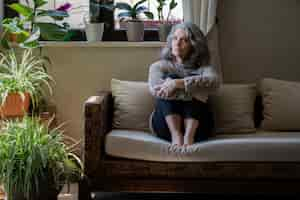 Free photo sad elder woman on the sofa