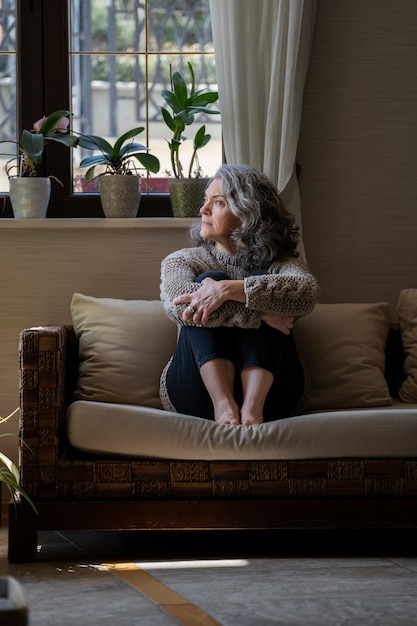 Free photo sad elder woman on the sofa