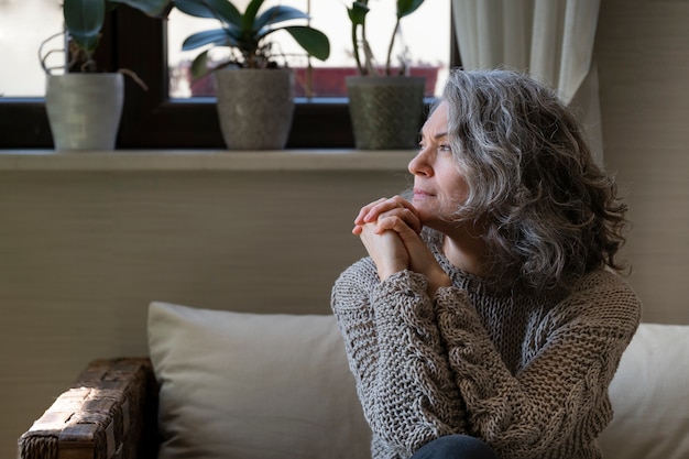 Free photo sad elder woman on the sofa