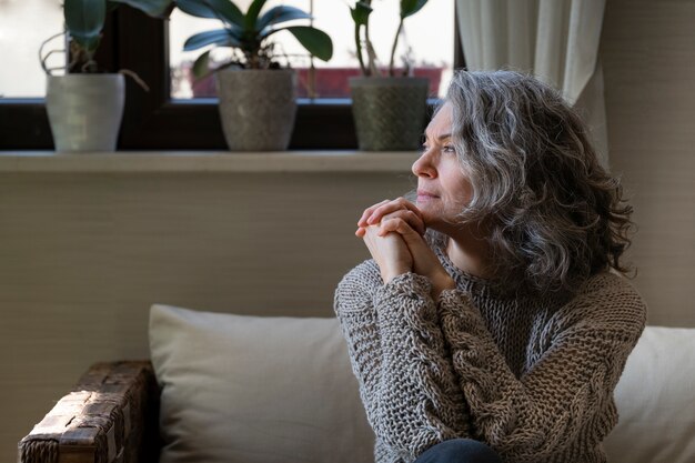 Sad elder woman on the sofa