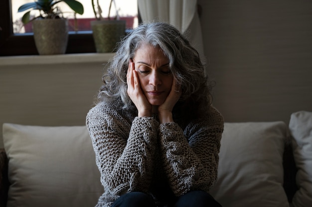 Sad elder woman on the sofa