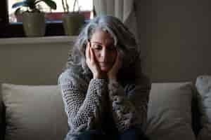 Free photo sad elder woman on the sofa