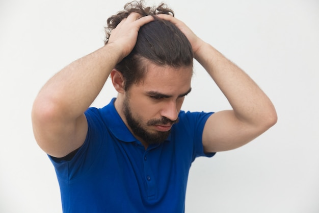 Sad frustrated guy holding head with both hands