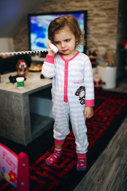 Free photo sad girl talking on phone in living room