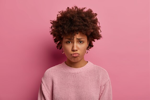 sad gloomy woman pouts lips, looks with sorrowful expression