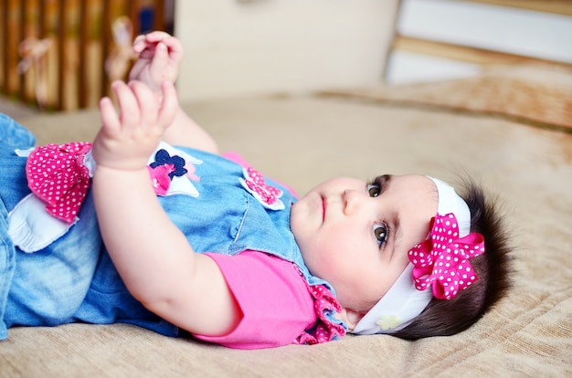 Free photo sad little girl lying on bed