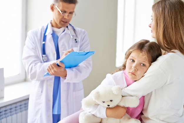 Free photo sad little girl in the medical office