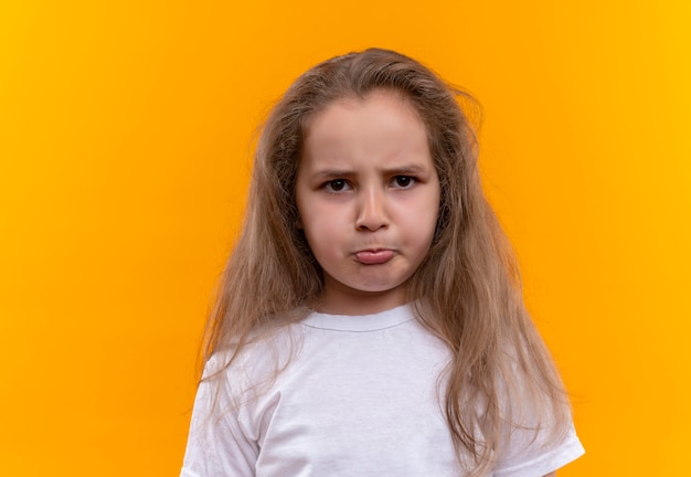 Free photo sad little school girl wearing white t-shirt on isolated orange background