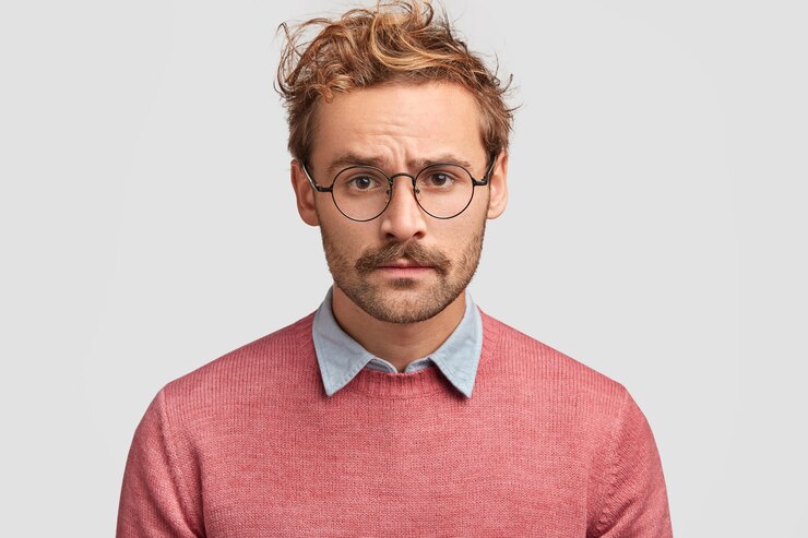 Free Photo sad lonely man with displeased expression, looks seriously at camera, being depressed as doesn`t have serious relationship