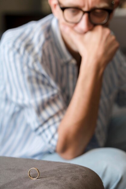 Sad man looking at wedding ring