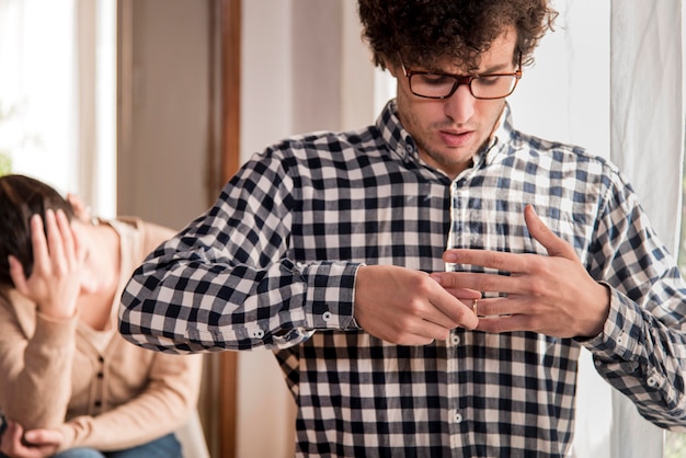 Free photo sad man pulling out wedding ring