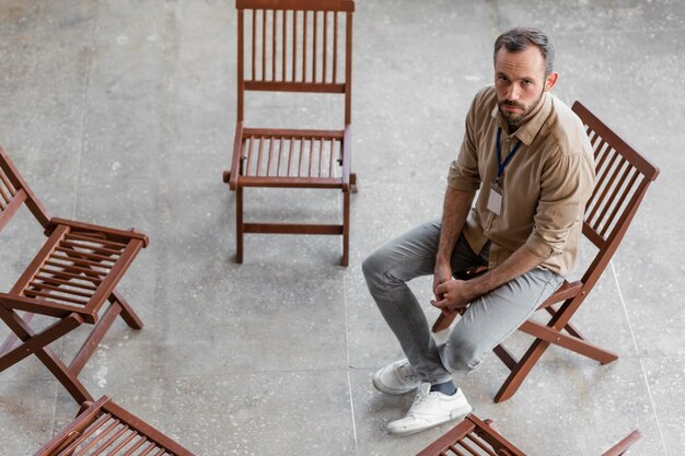 Sad man sitting on chair full shot