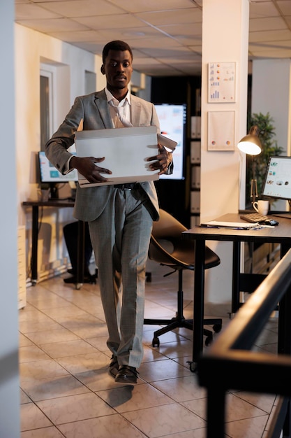 Free photo sad manager carrying cardboard box with belongings