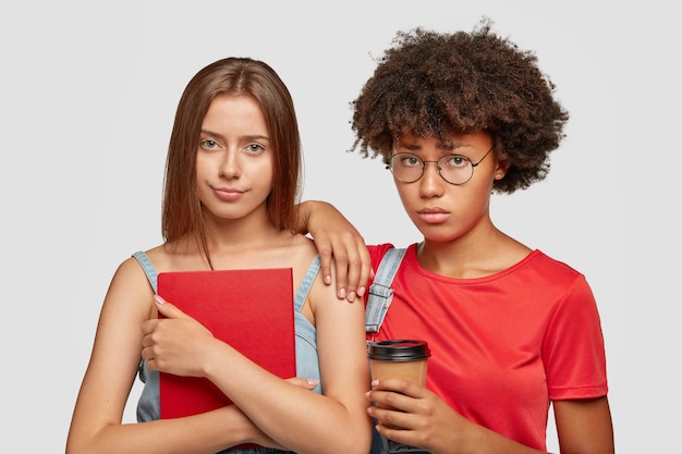 Sad mixed race women friends have unhappy looks