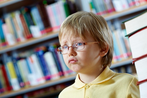 Foto gratuita allievo triste in biblioteca