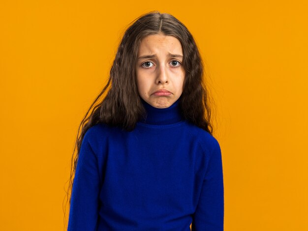 Грустная девочка-подросток, изолированные на оранжевой стене