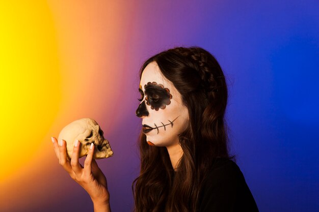 Sad witch looking at skull