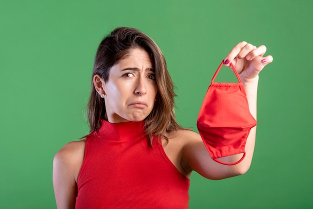 Free photo sad woman holding mask