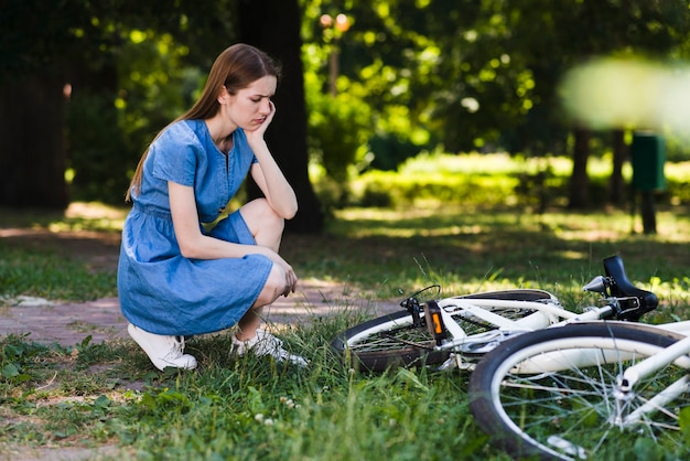 Sad woman looking at her bicycle