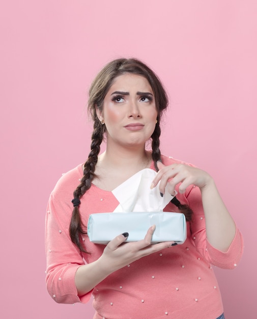 Free photo sad woman looking up and holding box of napkins