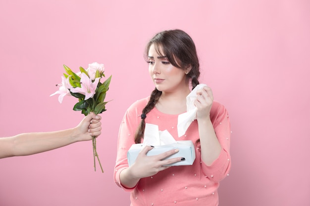 Sad woman receiving lily bouquet while holding napkins