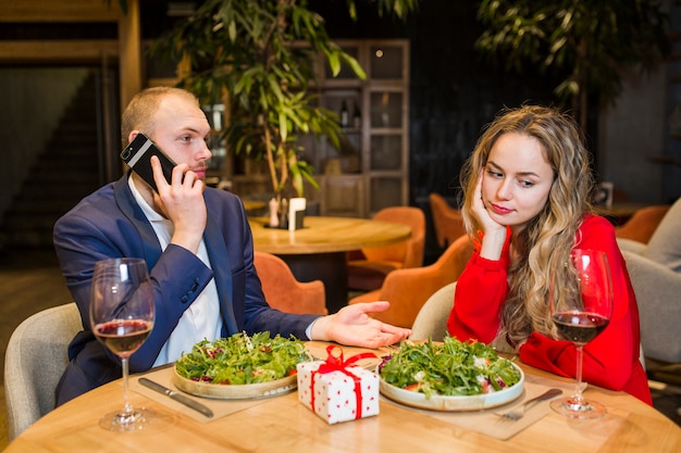 Free photo sad woman sitting at table in restaurant