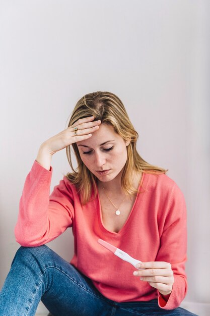 Sad woman with pregnancy test