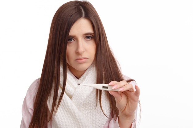 Free photo sad young woman holding a thermometer