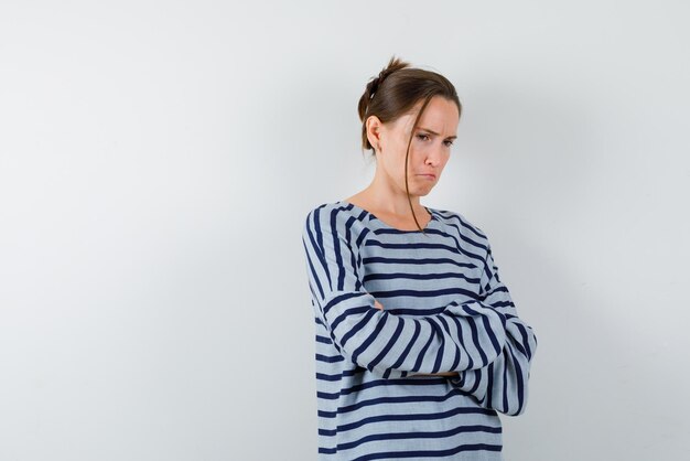 Sad young woman on white background